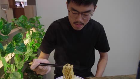 Hombre-Comiendo-Sopa-Tradicional-Asiática-De-Fideos-Singapurenses-En-Cámara-Lenta-Meepok-Con-Huevo-Y-Carne-Picada
