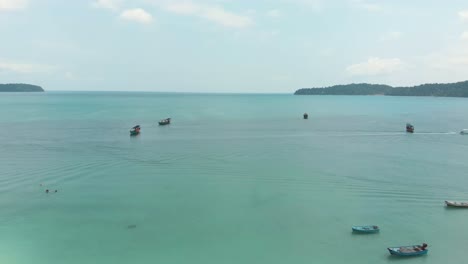 Panoramic-view-of-encircling-bay-populated-by-fishing-boats-moored-above-the-turquoise-sea-in-Saracen-Bay-in-Koh-Rong-Sanloem,-Cambodia---Aerial-Panoramic-view