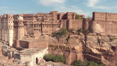 view-of-the-majestic-Mehrangarh-Fort's-facades-and-exterior-walls-surrounded-by-birds-of-prey-in-Jodhpur,-Rajasthan,-India---Aerial-establishing-shot