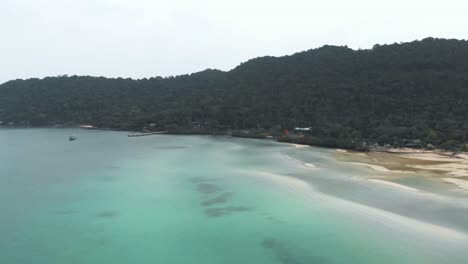 wide-view-of-Saracen-Bay-seaside-displaying-the-turquoise-shallow-waters-and-tropical-vegetation---Aerial-Panoramic-wide-shot
