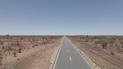 Niña-Caminando-Sola-En-Medio-De-Un-Camino-Distante-En-El-Desierto-Rojo-Del-Territorio-Del-Norte,-Australia