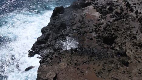 Nakalele-Blowhole,-Maui,-ocean-foamy-waves-crashing-on-volcanic-rocks,-aerial