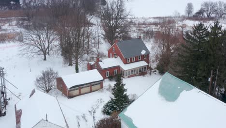 Aerial-of-family-farm,-farmhouse-home-covered-in-winter-snow