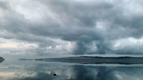 Timelapse,-islands-in-calm-lake-water-with-reflections-of-clouds-and-mist