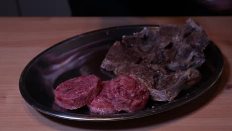 Preparing-a-silver-tray-of-boiled-beef-and-slices-of-italian-cotechino-sausage