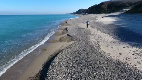 A-Young-Man-Walking-on-a-Gravel-Beach