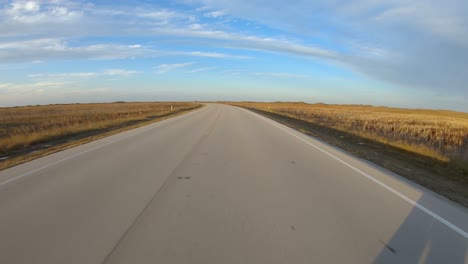 POV-while-driving-on-a-paved-road-thru-the-marshy-grasslands-of-North-Padre-barrier-island-along-the-gulf-shore-of-Texas-in-late-afternoon