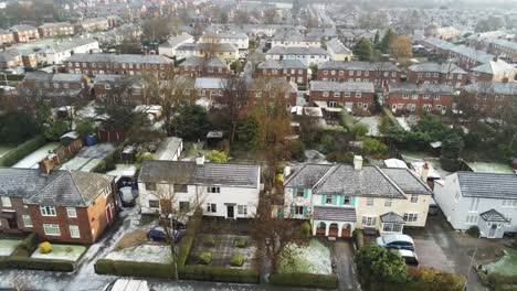 Aerial-view-frosty-white-winter-residential-town-neighbourhood-rooftops-descending-tilt-up