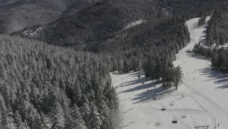 Ski-lift-going-downhill-at-Ribnica-one-in-Kope-ski-resort-Slovenia,-Aerial-dolly-in-shot