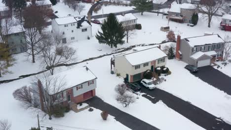 Aerial-establishing-shot-of-modest-split-level-homes-covered-in-fresh-winter-snow