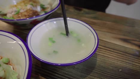 Sopa-Tradicional-Asiática-De-Fideos-Singapurenses-Que-Se-Revuelve-Con-Palitos-En-Cámara-Lenta-Meepok-Con-Huevo-Y-Carne-Picada