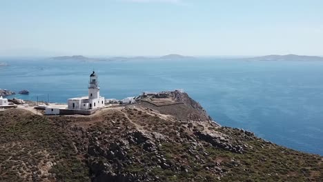 Lighthouse-On-Mykonos-Greece-Over-Beach-And-Cliff-Face