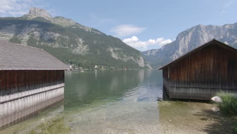 Wooden-boat-hangars-on-Altaussee-lake-and-mountain-panorama,-Austria