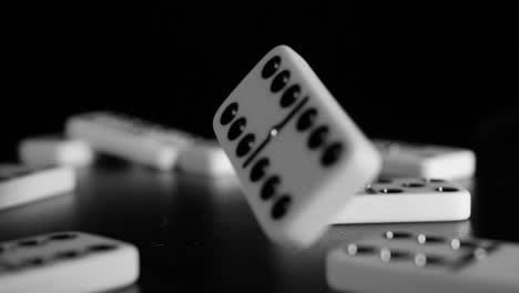 Weiße-Dominowürfel-Fallen-Auf-Einen-Schwarzen-Hintergrund