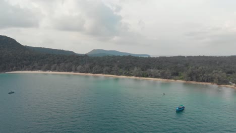 Wide-view-of-Lazy-Beach-Shoreline-under-a-cloudy-golden-hour-in-Koh-Rong-Sanloem,-Cambodia---Aerial-slow-fly-forward-shot