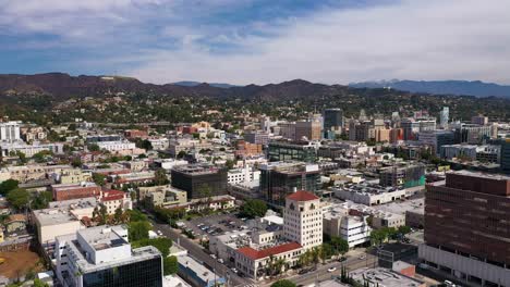 Low-aerial-shot-of-downtown-Hollywood-with-the-Hollywood-sign