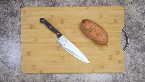 Setting-a-knife-down-next-to-a-sweet-potato