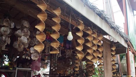 Decorative-wooden-helix-kinetic-wind-spinners-hanging-at-the-front-of-a-tropical-souvenir-shop
