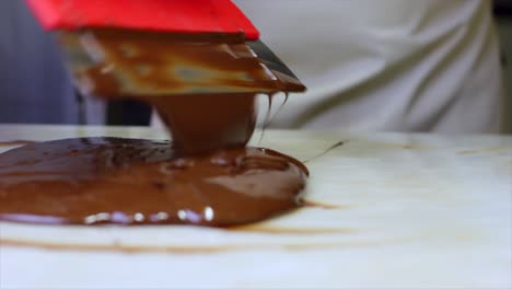 Tempering-melted-Chocolate-on-natural-Stone-with-spatula-Close-Up