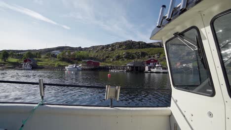 Segelndes-Fischerboot,-Das-Durch-Kleine-Hütten-Entlang-Des-Ruhigen-Ozeans-Und-Der-üppigen-Berge-In-Norwegen-Fährt
