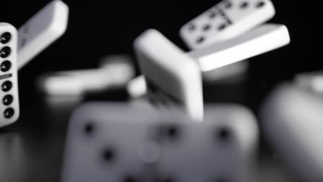 Weiße-Dominowürfel-Fallen-Auf-Einen-Schwarzen-Hintergrund