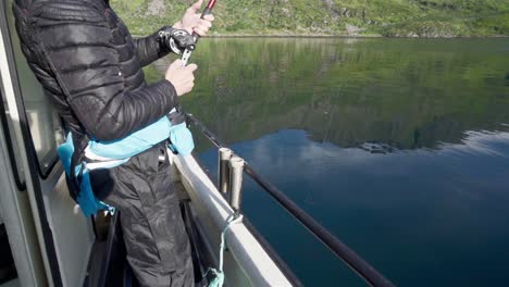 Man-Reeling-The-Fishing-Rod-Into-The-River-Of-Norway