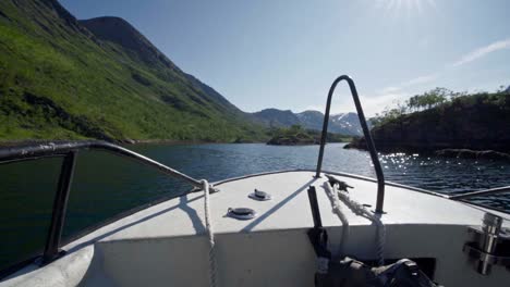 Barco-Navegando-Bajo-Un-Cielo-Soleado-Con-Un-Paisaje-De-Crestas-Al-Fondo-En-Noruega