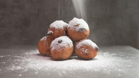 Sugar-powder-falling-on-Dutch-oil-balls-delicacy-with-sugar-powder-traditionally-eaten-on-New-Year's-Eve-in-The-Netherlands