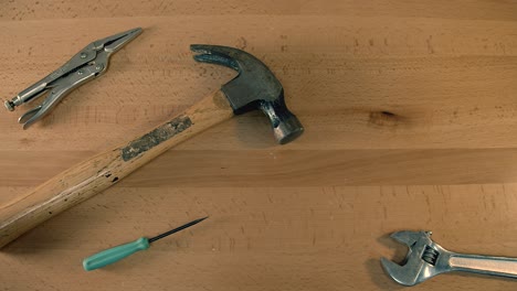 Top-down-view-of-tools-on-tabletop-grabbed-one-by-one