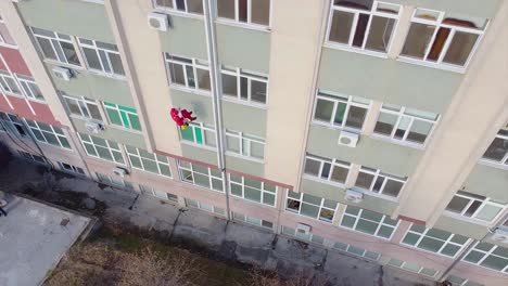 Rope-climber-dressed-as-Santa-climbing-down-an-exterior-wall-of-a-hospital