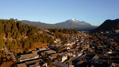 El-Casco-Antiguo-De-La-Ciudad-De-Lijiang-Y-La-Montaña-Nevada-Del-Dragón-De-Jade,-Yunnan,-China,-Vista-Aérea