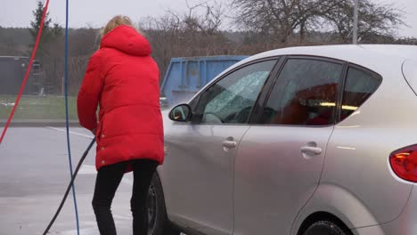 Slow-motion-shot-of-woman-washing-her-car-during-winter