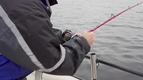 Hombre-En-Barco-Rodando-Rápidamente-La-Caña-De-Pescar-En-El-Río-En-Noruega