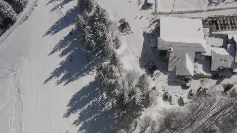 Ski-Track-at-Kope-winter-resort-Slovenia-with-skiers-going-downhill,-Aerial-top-view-flyover-shot