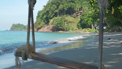 tropical-beach-in-Thailand-with-rope-swing-and-jungle-coastline,-static-shot-with-zoom
