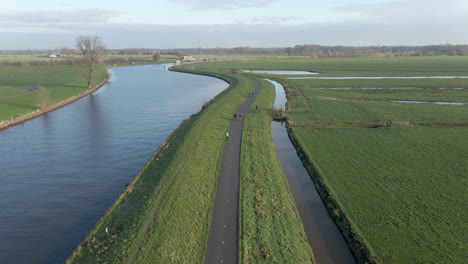 Aerial-of-cyclists-and-joggers-moving-over-dike-in-the-Netherlands