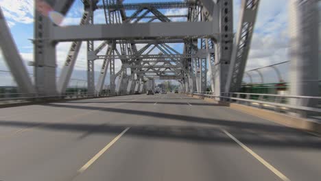 Rear-facing-driving-point-of-view-POV-on-large-modern-girder-bridge-with-multi-lane-elevated-freeway-flyover-on-Brisbane's-Story-Bridge---ideal-for-interior-car-scene-green-screen-replacement