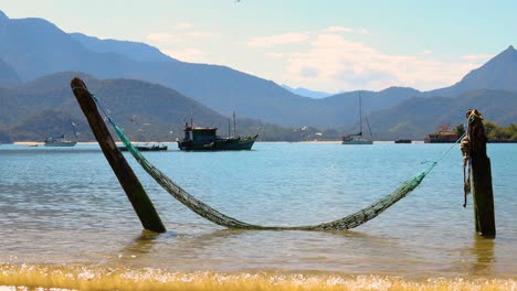 Hammock-in-the-water-with-peaceful-sea-background-with-fishing-boat-with-birds-flying