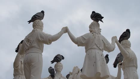 Pigeons-perched-on-some-dancing-statues