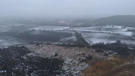Establishing-Aerial-Panning-Shot,-First-Little-Snow-on-Foggy-Landscape