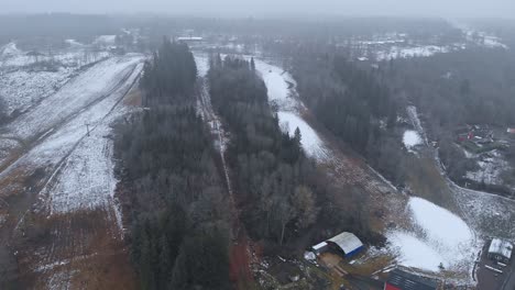 First-Little-Snow-on-Ski-Resort-Mountain-Slope,-Aerial-View,-Foggy-Day