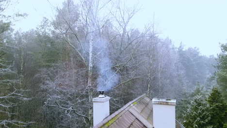 Blauer-Rauch-Von-Einem-Offenen-Feuer,-Das-Aus-Einem-Schornstein-Eines-Alten-Hauses-In-Bartoszylas-Polen-Kommt