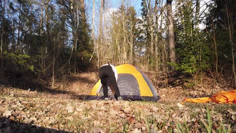 Girl-In-A-Hood-Built-A-Tent-In-The-Woods-Alone-In-A-Campsite---Medium-Shot,-Slow-Motion