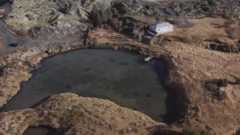 Pequeña-Cabaña-Con-Muelle-Privado-En-El-Lago-En-El-Paisaje-De-Islandia,-Antena