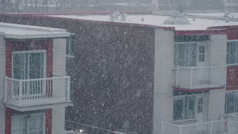 Slow-Motion-Cold-Winter-Snow-Falling-in-Front-of-Apartment-Building-with-Balconies-and-Windows