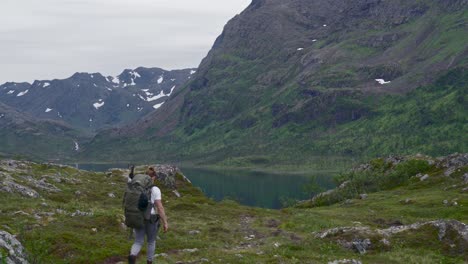 Mochilero-Caminando-Hacia-El-Lago-Junto-A-La-Montaña-En-Noruega-Durante-El-Invierno,-Tiro-Amplio,-Estático