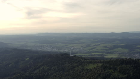 Slow-wide-aerial-of-green-landscape-and-rural-town,-Czech-Republic