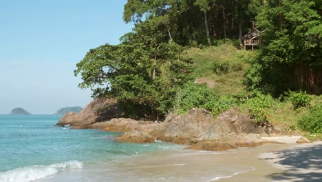 white-sand-tropical-beach-with-cliff-and-jungle-with-bamboo-hut-in-Thailand