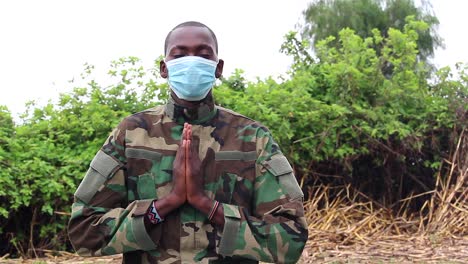 African-soldier-praying-with-covid-mask-on