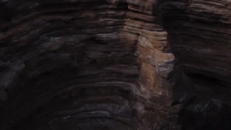 Drone-aerial-cliffside-pan-down-rock-on-waves-Hawaii